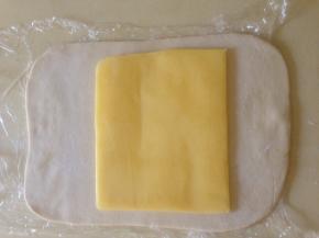 面团冷冻大约30分钟  取出  片状黄油放在面片中间  用面片把黄油包好 接口处压紧