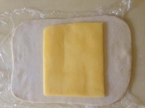 面团冷冻大约30分钟  取出  片状黄油放在面片中间  用面片把黄油包好 接口处压紧