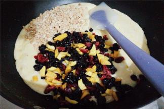 倒入混合果干和花生碎，混合均匀，把材料包裹进去