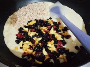 倒入混合果干和花生碎，混合均匀，把材料包裹进去