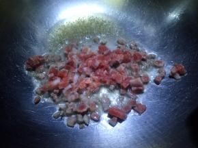 锅内放油烧至五成热，放入肉丁翻炒至变色