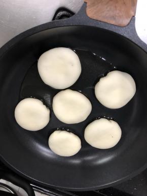 不粘锅放少许油，包好的包子放入锅中轻压成饼状，加入半碗水，盖上盖子，烹制