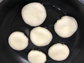 不粘锅放少许油，包好的包子放入锅中轻压成饼状，加入半碗水，盖上盖子，烹制