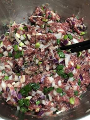 加入适量的盐、糖、酱油、玉米淀粉，拌匀。加入少量的水，按一个方向搅动牛肉，让水与牛肉好好融合，反复加水，搅匀这个动作3，4次。最后加入洋葱葱花拌匀，馅料准备好了。