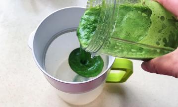 搅打好的菠菜汁倒入过滤杯子里