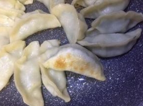 饺子在煎制过程中需要晃动锅两三次，以达到受热均匀的效果，水干后饺子皮变微透明底部已有焦黄色