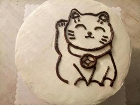 把凝固好的巧克力招财猫取下来放在蛋糕上。