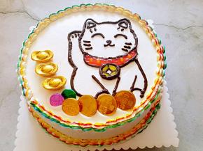 挤上红色和黄色的果膏，再摆上金币巧克力，和元宝巧克力装饰一下。