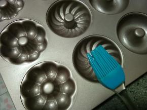 刚刚倒完黄油的小盘会剩下一点黄油根儿，用刷子或者手指蘸黄油把模具涂抹一遍。其实好的不粘模具是不会粘的，只是正好有没倒干净的黄油就可以利用一下。