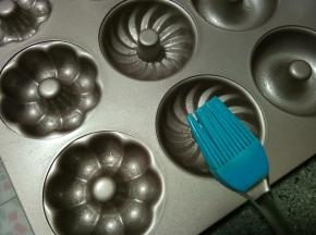 刚刚倒完黄油的小盘会剩下一点黄油根儿，用刷子或者手指蘸黄油把模具涂抹一遍。其实好的不粘模具是不会粘的，只是正好有没倒干净的黄油就可以利用一下。