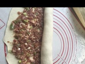 将拌好的馅料均匀涂抹在面皮上，自上而下卷起，两份都做完，醒发20分钟。