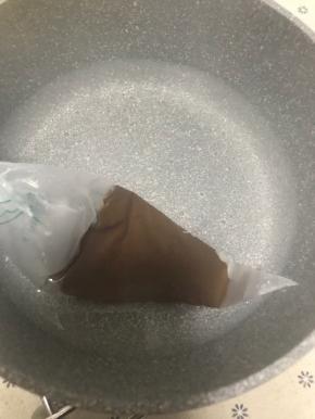 巧克力放进热水里融化，把裱花袋剪个极小的口子，用巧克力酱在面包上画上小狗的眉毛和眼睛