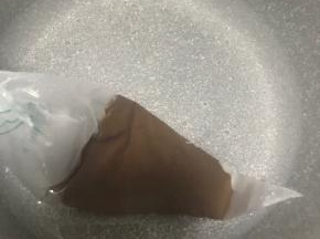 巧克力放进热水里融化，把裱花袋剪个极小的口子，用巧克力酱在面包上画上小狗的眉毛和眼睛