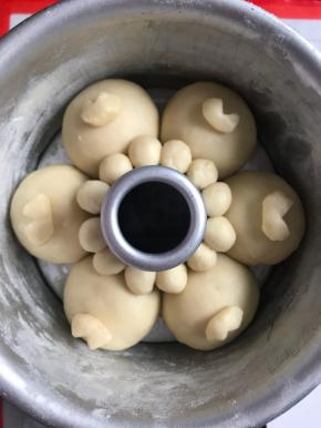 再把剩余的面团分成12个每个两克左右的小面团，继续揉圆，靠着烟囱模摆放，充当小狗的耳朵