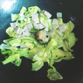 再加入火腿片和肉丸翻炒1分钟