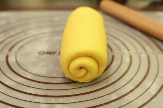 取1小份面团，擀成椭圆形，翻面从上往下卷好，二次醒发20分钟