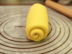 取1小份面团，擀成椭圆形，翻面从上往下卷好，二次醒发20分钟