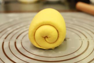 再次将面团擀成牛舌状，翻面从上往下卷好