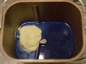 取158克的碟豆花水倒入面包机桶内，再放入牛奶、糖、奶粉、鸡蛋、炼乳