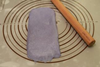 取一小份面团，擀成牛舌状，翻面