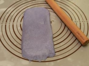 取一小份面团，擀成牛舌状，翻面