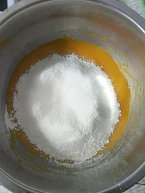 6.过筛好以后继续用蛋抽画“Z”字形，把面粉和南瓜泥混合均匀。千万不可画圈，因为面粉会起筋哦～