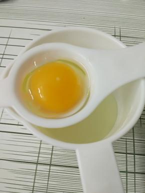 8.接下来处理鸡蛋，我用鸡蛋分离器一个个把蛋清和蛋黄分离，分离完一个，蛋黄倒入南瓜面糊中，蛋清倒入无水无油的另外一个打蛋盆中。
记住，一定要一个个分离，假如你偷懒分完一个没有把蛋清倒入盆中，打第二个鸡蛋，要是这鸡蛋坏了的话，惨了，前面一个蛋清也毁了，我就吃过这样的亏，痛心疾首啊～