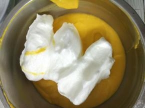 17.接下来，取出三分之一的蛋白霜到蛋黄糊中，用切拌和翻拌的手法将蛋白霜和蛋黄糊混合均匀。切记不能画圈，避免消泡哈～
