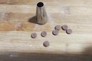 继续用小号圆形裱花嘴在可可面片上刻出8个小圆片，这是大黄狗的鼻子啦