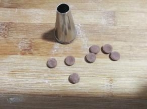 继续用小号圆形裱花嘴在可可面片上刻出8个小圆片，这是大黄狗的鼻子啦