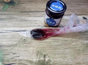 取一勺蓝莓酱，放进裱花袋，在裱花袋头上剪个口，如果用有整颗果肉的蓝莓酱，口要稍微大一些；