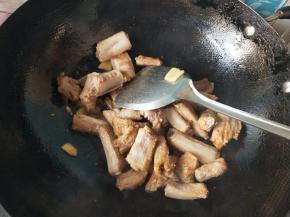 将排骨放入锅中，加酱油，料酒翻炒。