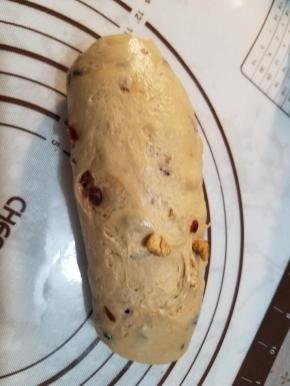 先取出一块面团，把面团擀成长条状后卷起，捏紧收口放入烤盘。