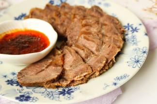 浸泡入味之后的牛肉，切片摆盘，放香菜也装饰一下。空口吃也很好吃，蘸上酸辣的蒜汁更是下酒好菜。