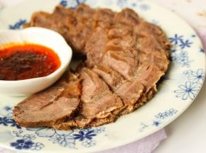 浸泡入味之后的牛肉，切片摆盘，放香菜也装饰一下。空口吃也很好吃，蘸上酸辣的蒜汁更是下酒好菜。