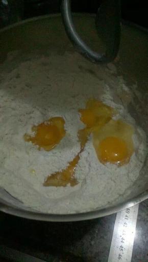 鸡蛋面粉酵母加上5克砂糖搅拌，要是太干就加适量水进去揉面。