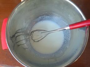 牛奶和玉米油加入盆内，混合乳化呈乳白色浓稠液体。