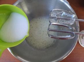 细砂糖分三次加入蛋白内。打蛋器打发至出现鱼眼泡，加入三分之一的细砂糖。