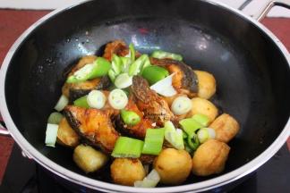 将炸锅的鱼块、大葱、青辣椒一起下锅；