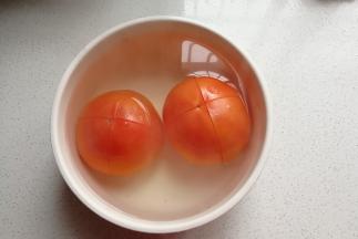 番茄两个先打上十字花刀，然后用滚开水烫一会儿，撕去番茄皮