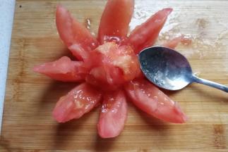 然后把外皮扒开，用勺子挖去内部的番茄籽扔掉，当然你也可以直接吃掉哈