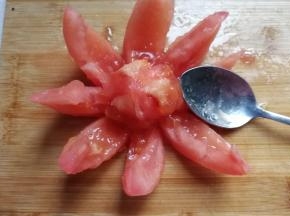 然后把外皮扒开，用勺子挖去内部的番茄籽扔掉，当然你也可以直接吃掉哈