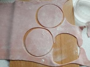 将面团切块用压面机压至适量的厚度，然后用饺子压模刻出饺子皮