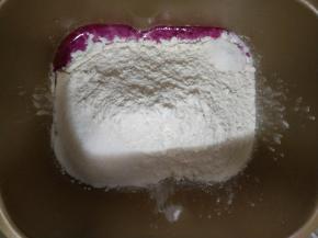 取火龙果汁210克先放入面包机 ，再放高筋面粉、盐和糖对角放，启动揉面程序10分钟左右。