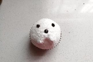 再继续用溶化的巧克力在半球奶油上挤出小狗的鼻头和眼睛