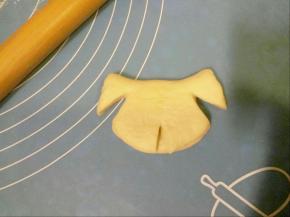 拿剪子把两边剪开一个口不要剪断，这样狗耳朵就出来了，然后把耳朵往上提，最下边再剪一个口剪出狗嘴