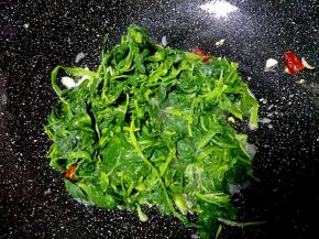 把菠菜放入锅中煸炒