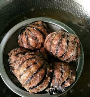 锅中加入油烧至六成热，把灯笼茄子下入锅中炸上四分钟左右，捞出控油