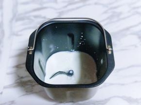 首先将牛奶放入面包桶中。