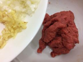 在把葱姜末加入肉馅中，顺着一个方向搅拌上劲腌制十分钟
